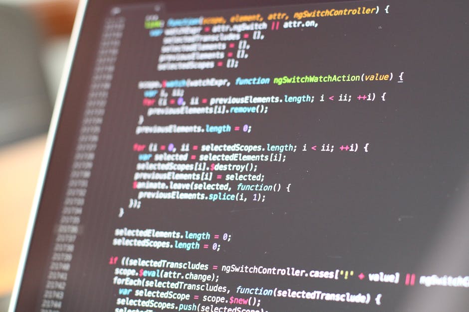 Close-up image of a computer screen displaying lines of colorful code, including functions, variables, and syntax highlighting. The screen shows a development environment with a dark background and mu
